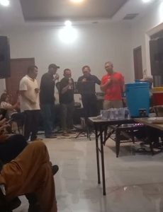 Foto 12. Foto bersama seusai acara hiburan malam di Lakeside Haus Balige, Jumat malam24 Juli 2026 — yang berakhir melewati tengah malam dan ditutup dengan ucapan selamat ulang tahun kepada Amang St. Reynhard Lumban Gaol. Tampak ornamen gorga Batak menghiasi dinding ruang utama penginapan