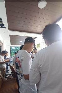 Foto 4. Latihan koor perdana di ruang utama Lakeside Haus Balige, Jumat 24 Juli 2026 pukul 10.30 WIB, tak lama setelah rombongan tiba dari Bandara Silangit. Dirigen Amang Parlis Sinaga memimpin dari depan sementara para peserta membaca partitur lagu yang akan dibawakan pada Ibadah Minggu di HKBP Balige.