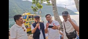 Foto 11. Suasana santai rombongan di kawasan Pantai Meat. Mengenakan kaos putih seragam, para peserta duduk melingkar di sekitar meja-meja plastik sambil menunggu hidangan ikan bakar disiapkan.