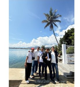 Foto 3. Sebagian rombongan berfoto di tanggul tepi Danau Toba, tepat di depan Lakeside Haus Balige. Di seberang teluk tampak kota Balige dengan latar pegunungan Tapanuli.