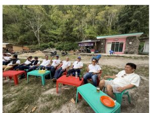 Foto 9. Suasana santai rombongan di kawasan Pantai Meat. Mengenakan kaos putih seragam, para peserta duduk melingkar di sekitar meja-meja plastik sambil menunggu hidangan ikan bakar disiapkan.