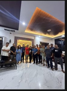Foto 12. Foto bersama seusai acara hiburan malam di Lakeside Haus Balige, Jumat malam 24 Juli 2026 — yang berakhir melewati tengah malam dan ditutup dengan ucapan selamat ulang tahun kepada Amang St. Reynhard Lumban Gaol. Tampak ornamen gorga Batak menghiasi dinding ruang utama penginapan