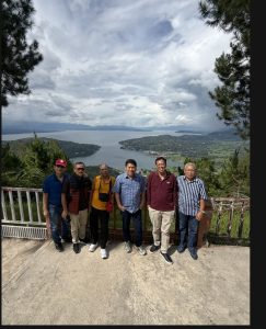 Foto 15. Sebagian rombongan Punguan Koor Ama HKBP Slipi berfoto di dek pandang Geopark Sipinsur, Humbang Hasundutan, Sabtu 25 Juli 2026. Di kejauhan tampak hamparan Danau Toba dengan Pulau Sibandang dan kawasan Muara.