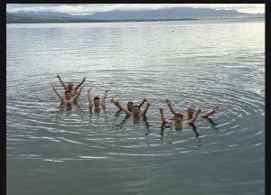 Foto 16. Berenang di Danau Toba pada Minggu pagi, 26 Juli 2026, tepat di depan penginapan Lakeside Haus Balige. Latar belakang memperlihatkan perbukitan di seberang danau yang masih tertutup awan pagi.